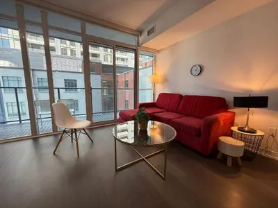 a living room with a red couch and a table at Gorgeous downtown condo in Toronto