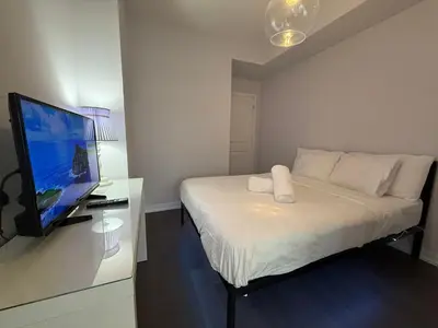 a small bedroom with a bed and a flat screen tv at Gorgeous downtown condo in Toronto