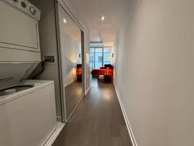 a hallway leading to a living room with a mirror at Gorgeous downtown condo in Toronto