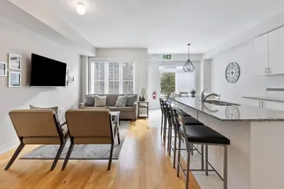 a kitchen and living room with a bar and chairs at Mountain View Townhouse Fresh and Bright at Blue in Collingwood