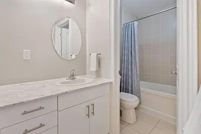 a bathroom with a sink and a toilet and a mirror at Mountain View Townhouse Fresh and Bright at Blue in Collingwood