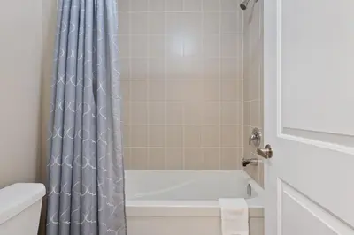 a bathroom with a tub and a shower curtain at Mountain View Townhouse Fresh and Bright at Blue in Collingwood
