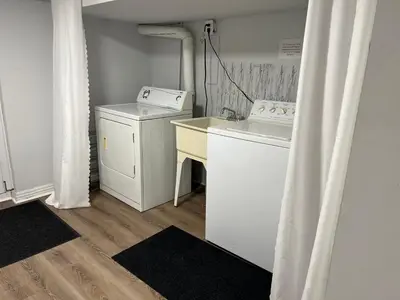a laundry room with a washing machine and a washer at Cozy basement 2 bedroom 2 bath with parking in Richmond Hill