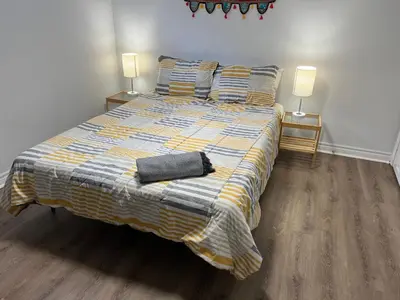 a bedroom with a bed with a blanket and two lamps at Cozy basement 2 bedroom 2 bath with parking in Richmond Hill