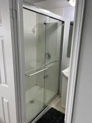 a glass shower in a bathroom with a sink at Cozy basement 2 bedroom 2 bath with parking in Richmond Hill