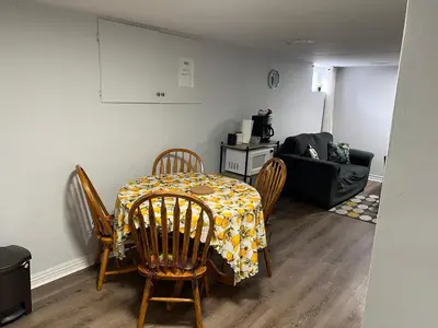 a dining room with a table and chairs and a couch at Cozy basement 2 bedroom 2 bath with parking in Richmond Hill