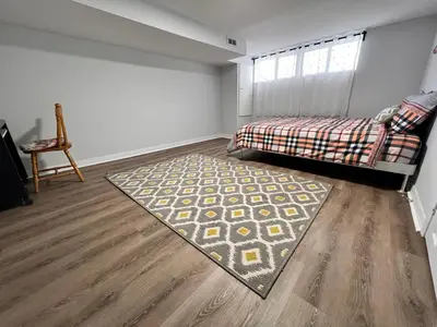 a bedroom with a bed and a rug on the floor at Cozy basement 2 bedroom 2 bath with parking in Richmond Hill