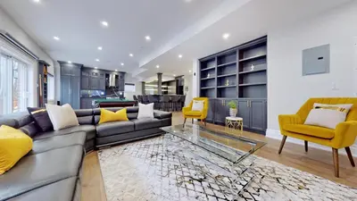 a living room with a gray couch and yellow chairs at Family Modern walkout Basement wSauna Indoor Fireplace Wifi in Innisfil