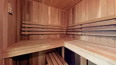 an empty sauna with wooden panels and wooden shelves at Family Modern walkout Basement wSauna Indoor Fireplace Wifi in Innisfil