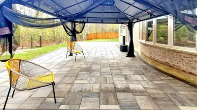 two chairs sitting on a patio under a blue canopy at Family Modern walkout Basement wSauna Indoor Fireplace Wifi in Innisfil