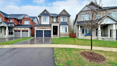a large house with a tree in the front yard at Family Modern walkout Basement wSauna Indoor Fireplace Wifi in Innisfil