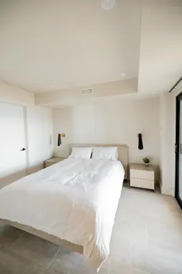 a white bedroom with a large bed and a window at Lakeview House by Leavetown Vacations in Lakefield
