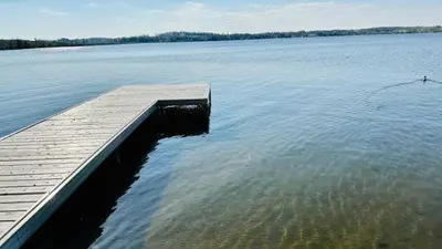 a dock in the middle of a large body of water at Lakeview House by Leavetown Vacations in Lakefield