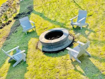 three chairs and a fire pit in the grass at Lakeview House by Leavetown Vacations in Lakefield