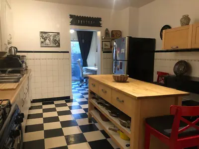 a kitchen with a refrigerator and a table in it at Beautiful house in central Toronto with backyard in Toronto