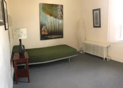 a living room with a green couch and a painting at Beautiful house in central Toronto with backyard in Toronto
