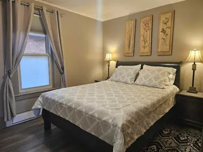 a bedroom with a large bed and a window at France and Flowers - Private 3-Bed Apartment in Stratford