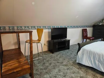 a bedroom with a bed and a desk and a television at France and Flowers - Private 3-Bed Apartment in Stratford