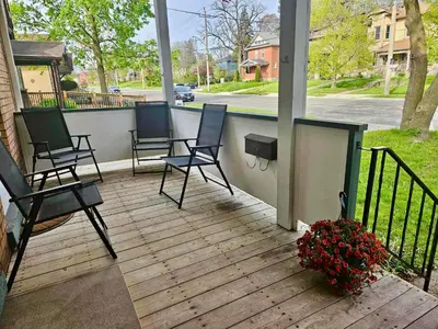 a porch with two chairs and a plant with flowers at France and Flowers - Private 3-Bed Apartment in Stratford