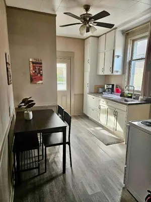 a kitchen with a table and a ceiling fan at France and Flowers - Private 3-Bed Apartment in Stratford