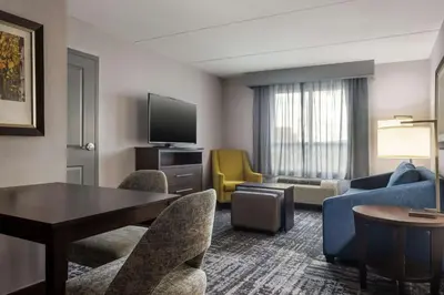 a hotel room with a table and chairs at Homewood Suites by Hilton Waterloo/St. Jacobs in Waterloo