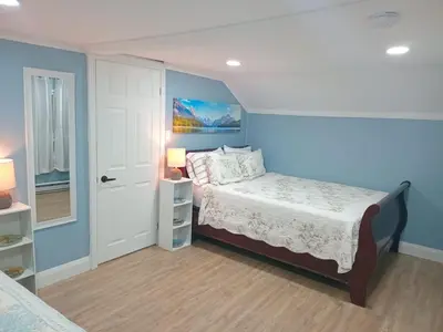 a bedroom with a bed and a blue wall at Windspire Inn in Port Elgin