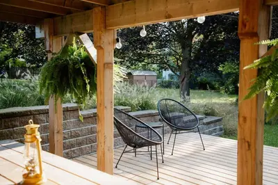 two chairs and a table on a wooden deck at The Dainty Petunia in Picton