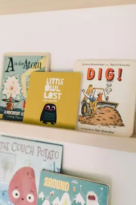 a shelf with childrens books on it at Fox Lane - Prince Edward County Farmhouse in Picton