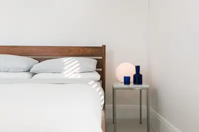 a bedroom with two beds and a side table at Hart House a fresh 3 bedroom century home in Cherry Valley