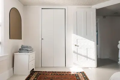 a white room with a door and a rug at Hart House a fresh 3 bedroom century home in Cherry Valley