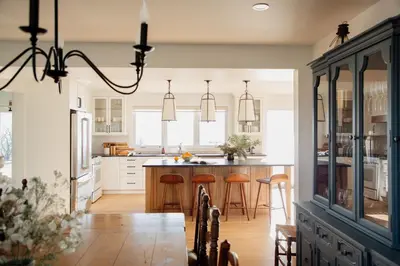 a kitchen with white cabinets and a large island with bar stools at The Hull House - Lake Ontario Waterfront w Sauna in Wellington