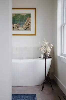 a bath tub in a bathroom with a picture on the wall at The Hull House - Lake Ontario Waterfront w Sauna in Wellington