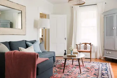 a living room with a blue couch and a table at Watson House - Century Home near Sandbanks in Cherry Valley
