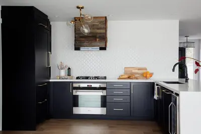 a kitchen with dark blue cabinets and a stove at Wellers Landing - Prince Edward County Lakehouse in Carrying Place