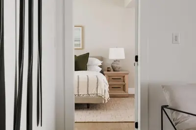 a bedroom with a bed and a table with a lamp at Wellers Landing - Prince Edward County Lakehouse in Carrying Place