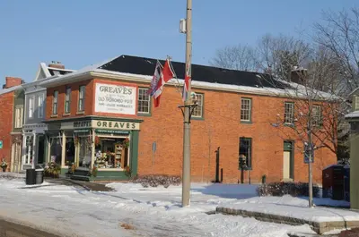 a red brick building with a flag in front of it at Greaves Sweet Escape in Niagara on the Lake