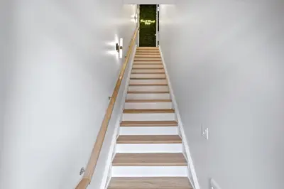 a staircase in a house with white walls and wooden floors at The Goodman: Front Street Flats in Belleville