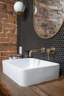 a bathroom with a white sink and a mirror at The Goodman: Front Street Flats in Belleville