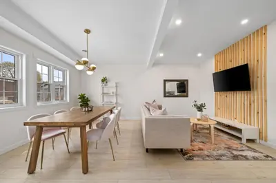 a dining room with a table and chairs and a tv at The Belvedere:Front Street Flats in Belleville