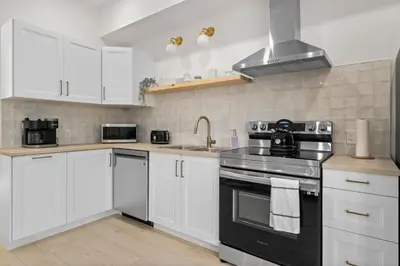 a kitchen with white cabinets and a stove top oven at The Belvedere:Front Street Flats in Belleville