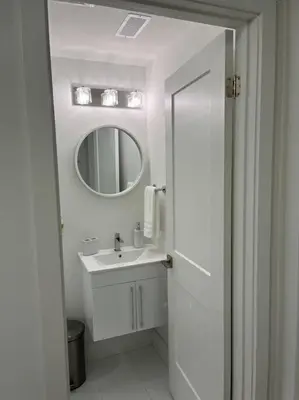 a white bathroom with a sink and a mirror at Lovely one bedroom condo with free parking in Niagara Falls