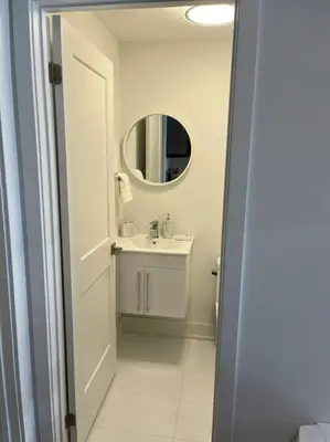 a white bathroom with a sink and a mirror at Lovely one bedroom condo with free parking in Niagara Falls