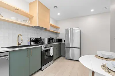 a kitchen with stainless steel appliances and a table at The Olympia: Front Street Flats in Belleville