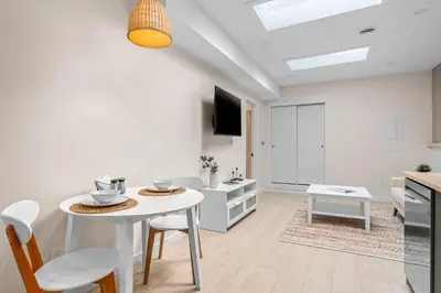 a kitchen and living room with a white table and chairs at The Olympia: Front Street Flats in Belleville