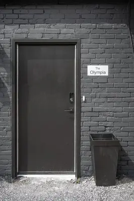a door to a brick building with a trash can at The Olympia: Front Street Flats in Belleville