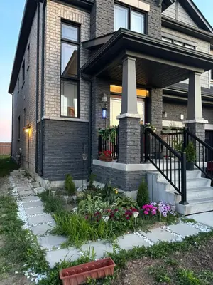 a house with a flower garden in front of it at Niagara Falls BNB 15 mins away from Falls in Thorold