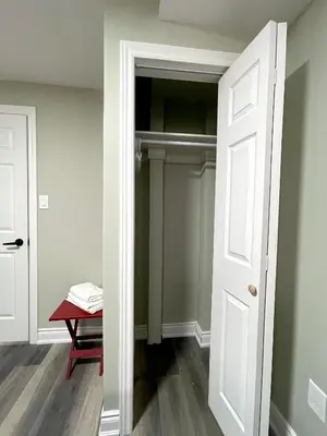 a closet with a white door and a red stool at Niagara Falls BNB 15 mins away from Falls in Thorold