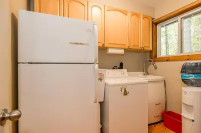 a kitchen with a white refrigerator and a sink at Muskoka Lakeshore Cottage Bliss in Gravenhurst