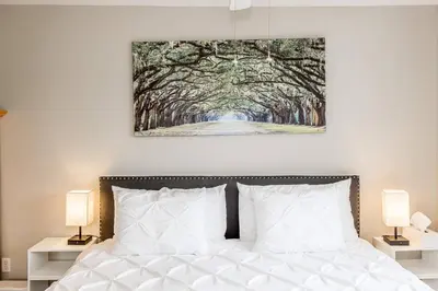 a bedroom with a bed with a painting on the wall at Muskoka Lakeshore Cottage Bliss in Gravenhurst