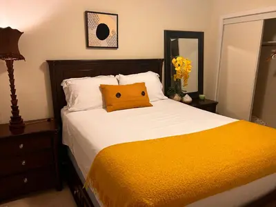 a bedroom with a bed with a yellow pillow on it at Jahsavvy's Nest in Hamilton